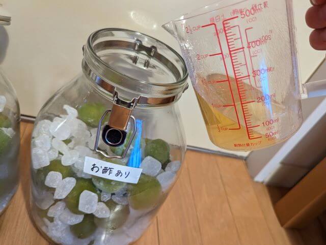 お酢ありの容器（すでに青梅と氷砂糖が入っている）に150mlのお酢を投入しているところ